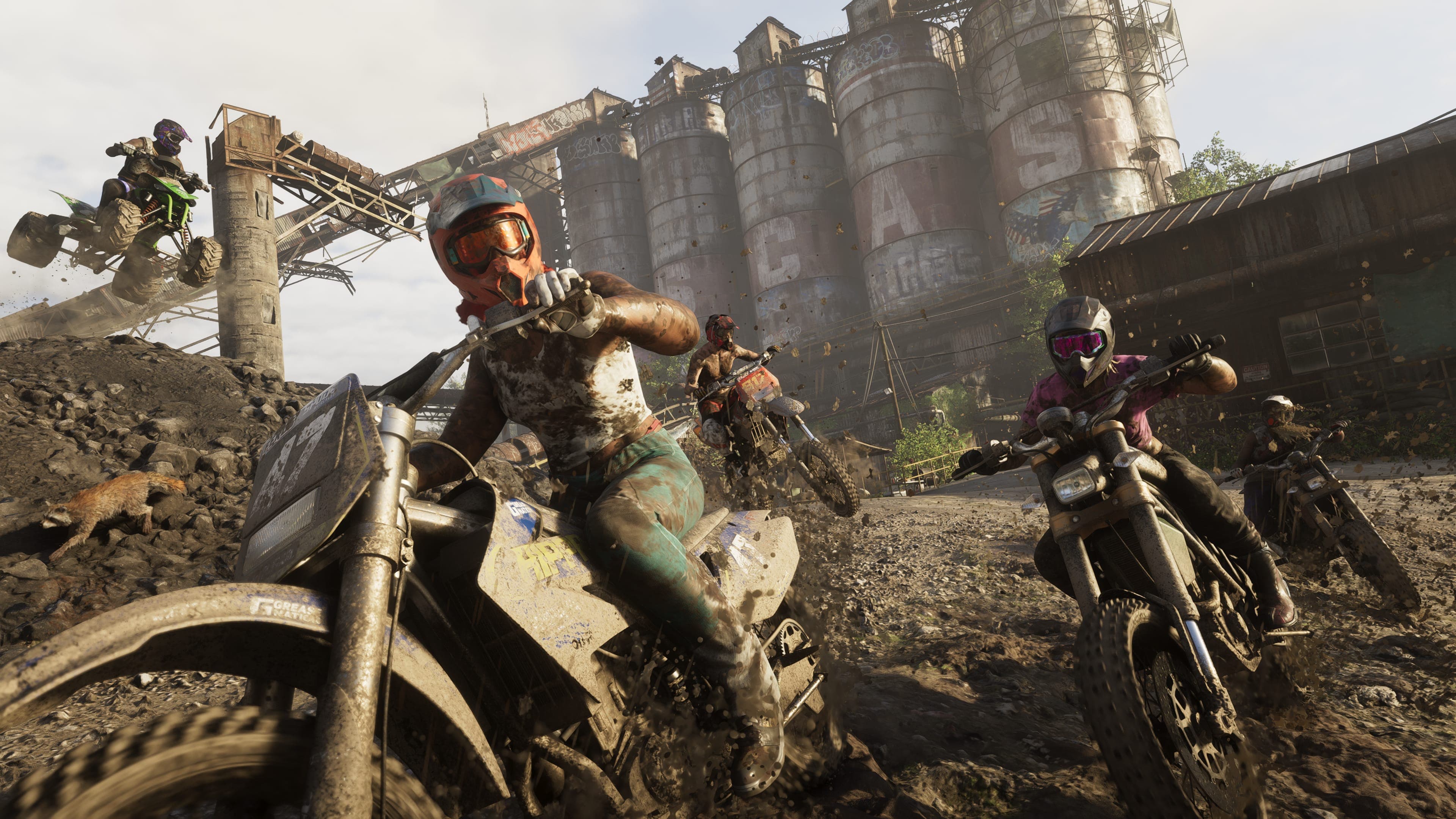 Pilotos de motocross e quadriciclo correndo na lama diante de silos abandonados em Mount Kalaga, em captura de tela oficial de GTA VI — a imagem é material de divulgação da Rockstar e não mostra o conteúdo vazado